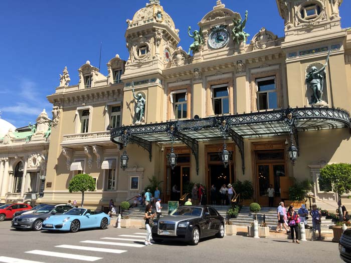 View of the front of the Monte Carlo Casino with beautiful cars lined up